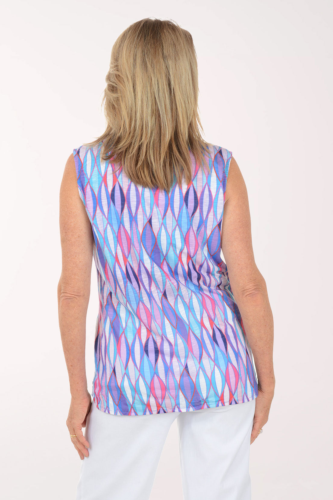 Woman wearing a sleeveless multicolored patterned top on a white background