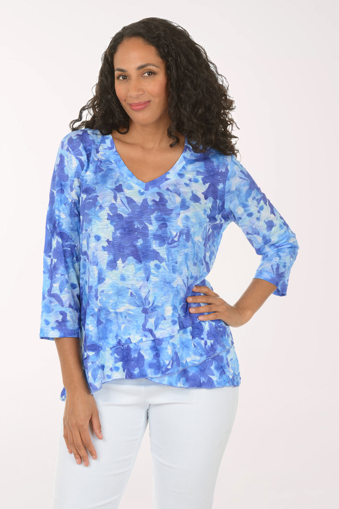 Woman wearing a blue floral blouse against a white background
