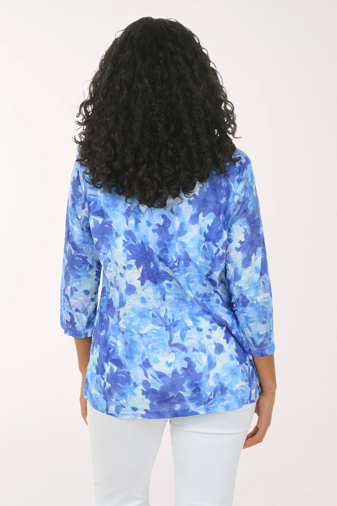Woman wearing a blue floral blouse against a white background
