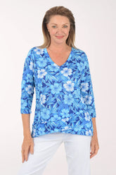 Woman wearing a blue floral print top on a white background