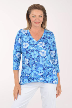 Woman wearing a blue floral print top on a white background