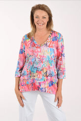 Woman wearing a colorful patterned top with text on a white background