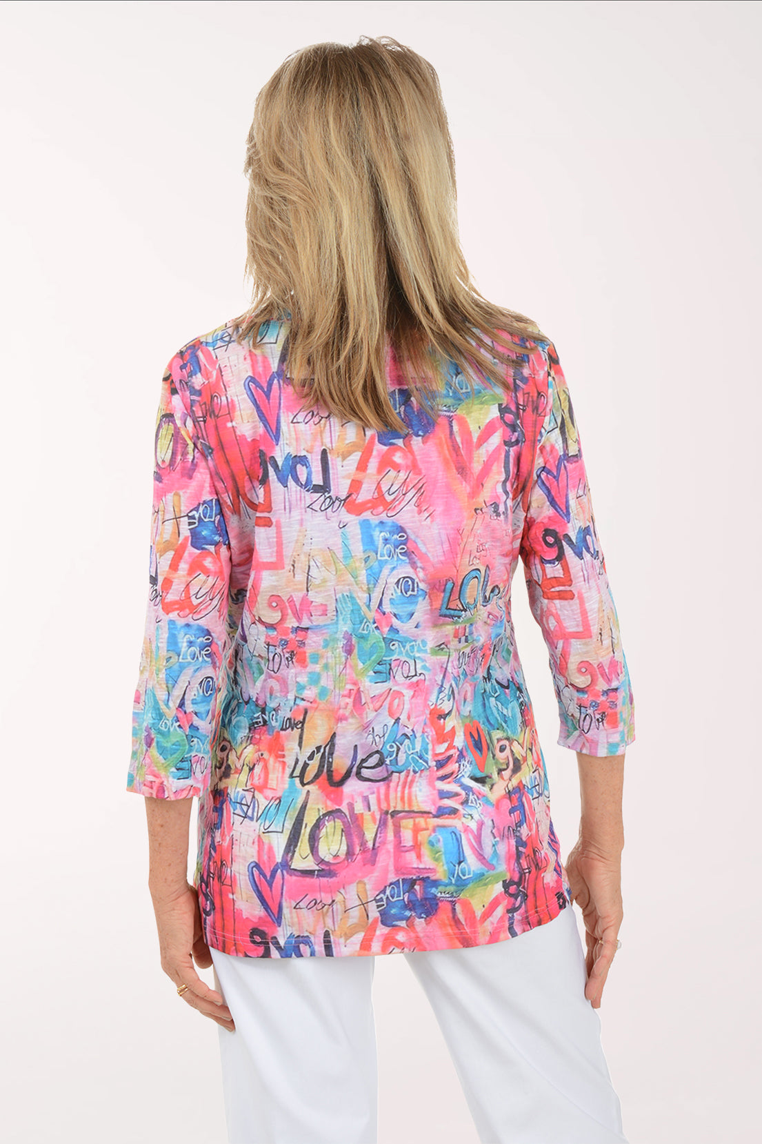 Woman wearing a colorful patterned top with text on a white background