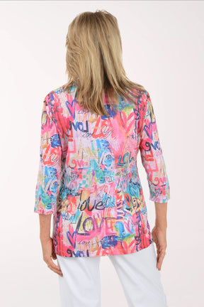 Woman wearing a colorful patterned top with text on a white background