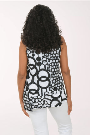 Woman wearing a sleeveless black and white patterned top on a white background