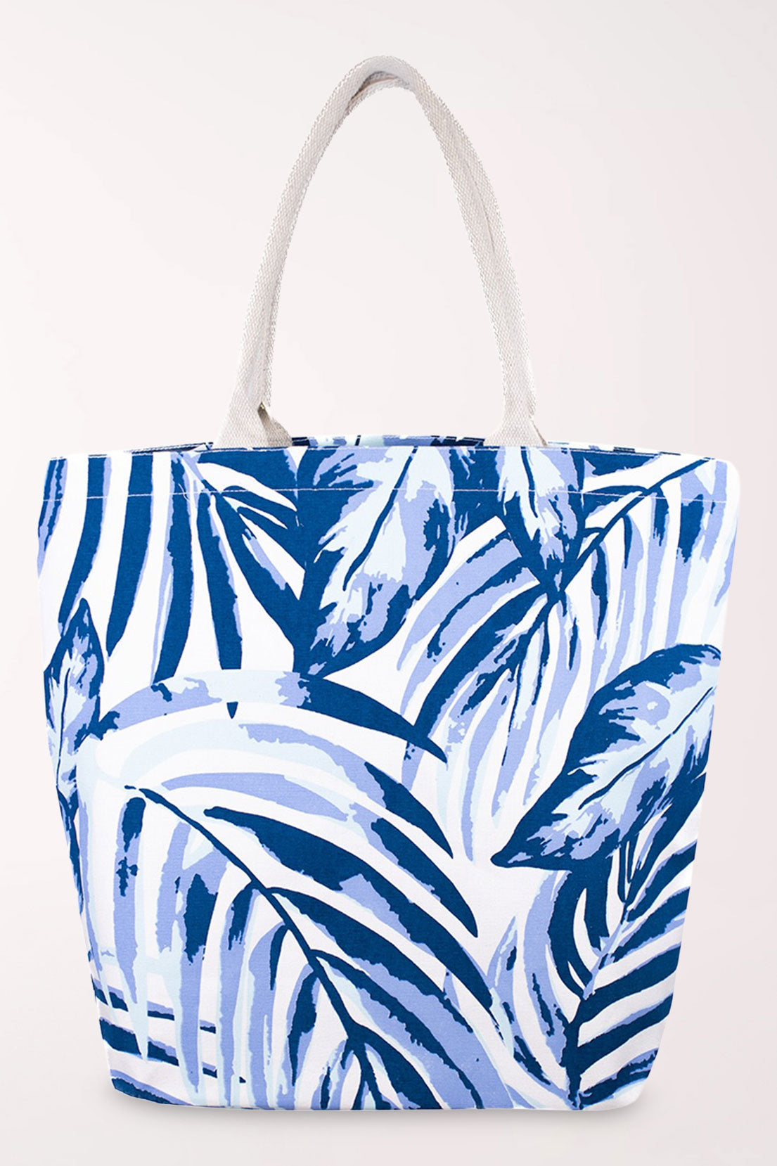 White cotton tote bag with an all-over palm leaf print in royal blue, periwinkle, and pale blue, with cream rope handles.