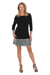 Front shot of a model wearing a 3/4 sleeve back dress with sequence at the bottom