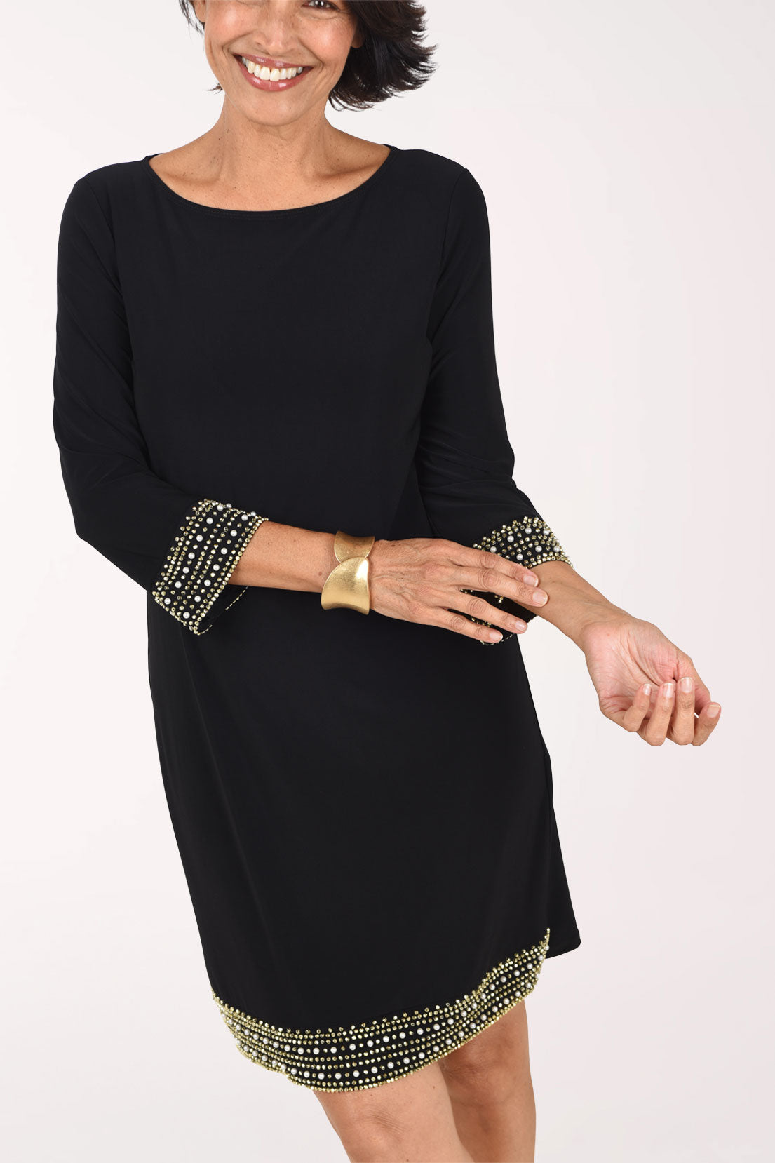 Close-up of the black Beaded Trim dress showing the rows of gold beads and small pearls on the 3/4 sleeve cuffs and along the hem
