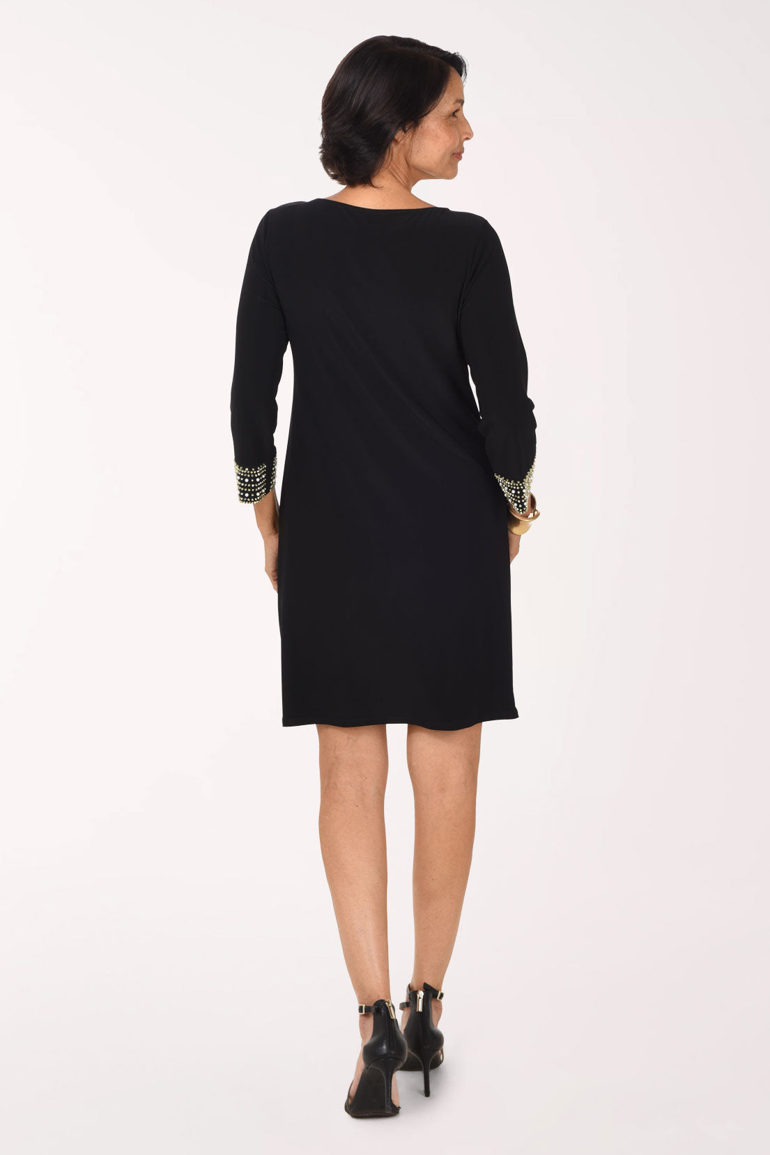 Back view of the black Beaded Trim dress showing a plain black back with a boat neckline and beaded trim visible at the sleeve cuffs