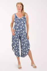 Woman wearing a blue floral jumpsuit on a white background