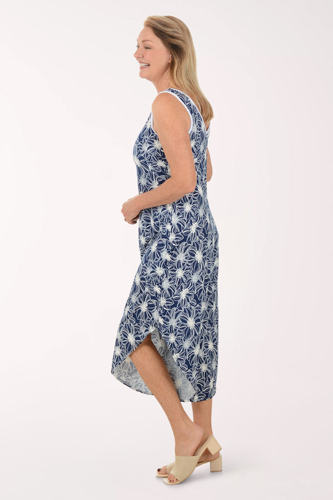 Woman wearing a blue floral jumpsuit on a white background
