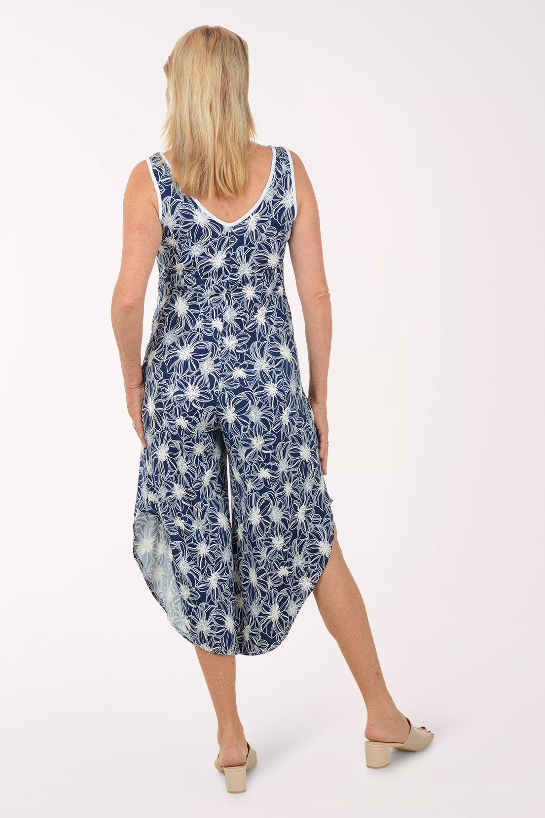 Woman wearing a blue floral jumpsuit on a white background