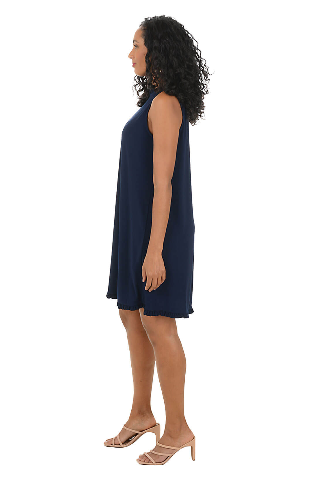 Woman wearing a navy sleeveless dress on a white background. Side shot