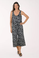 Woman wearing a black and white leaf-patterned jumpsuit on a white background