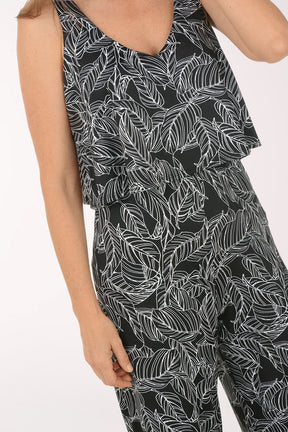 Woman wearing a black and white leaf-patterned jumpsuit on a white background