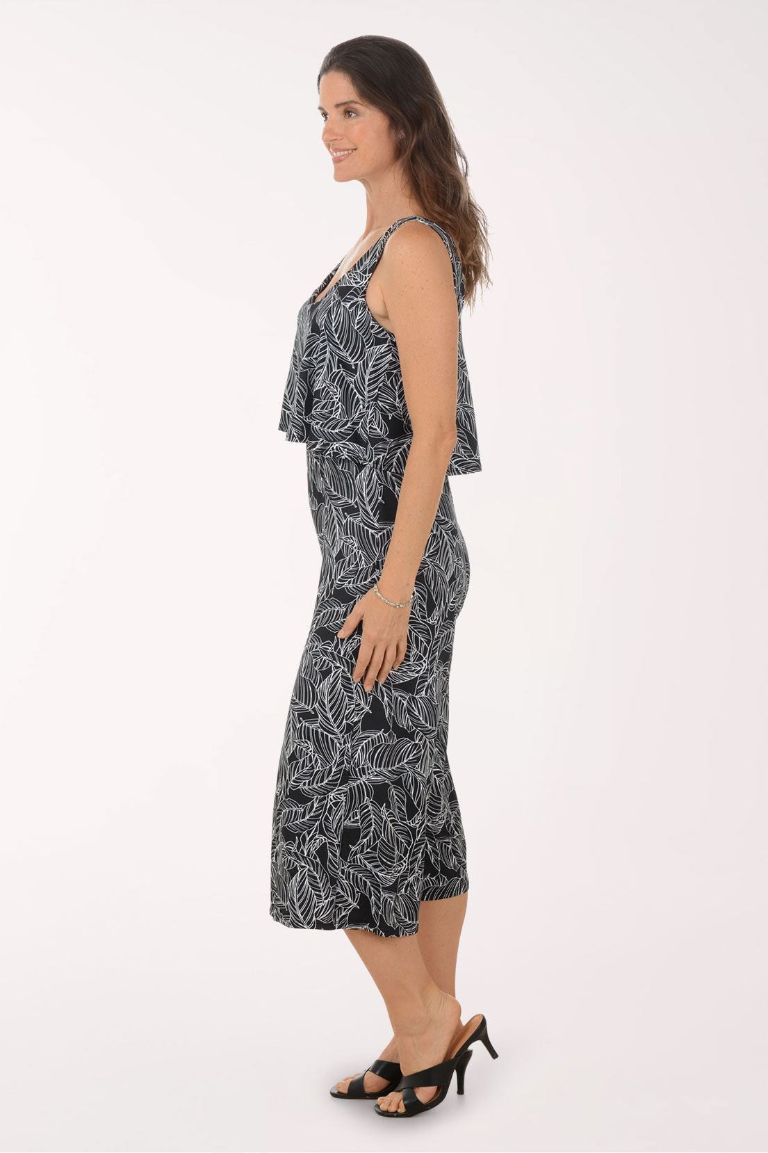 Woman wearing a black and white leaf-patterned jumpsuit on a white background