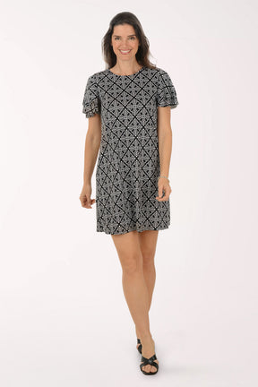 Woman wearing a black and white patterned dress on a white background