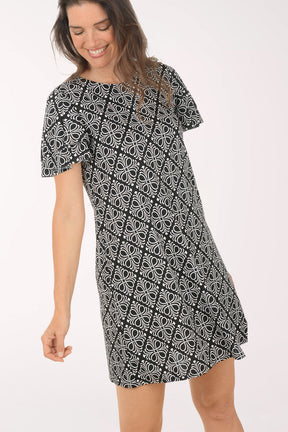 Woman wearing a black and white patterned dress on a white background