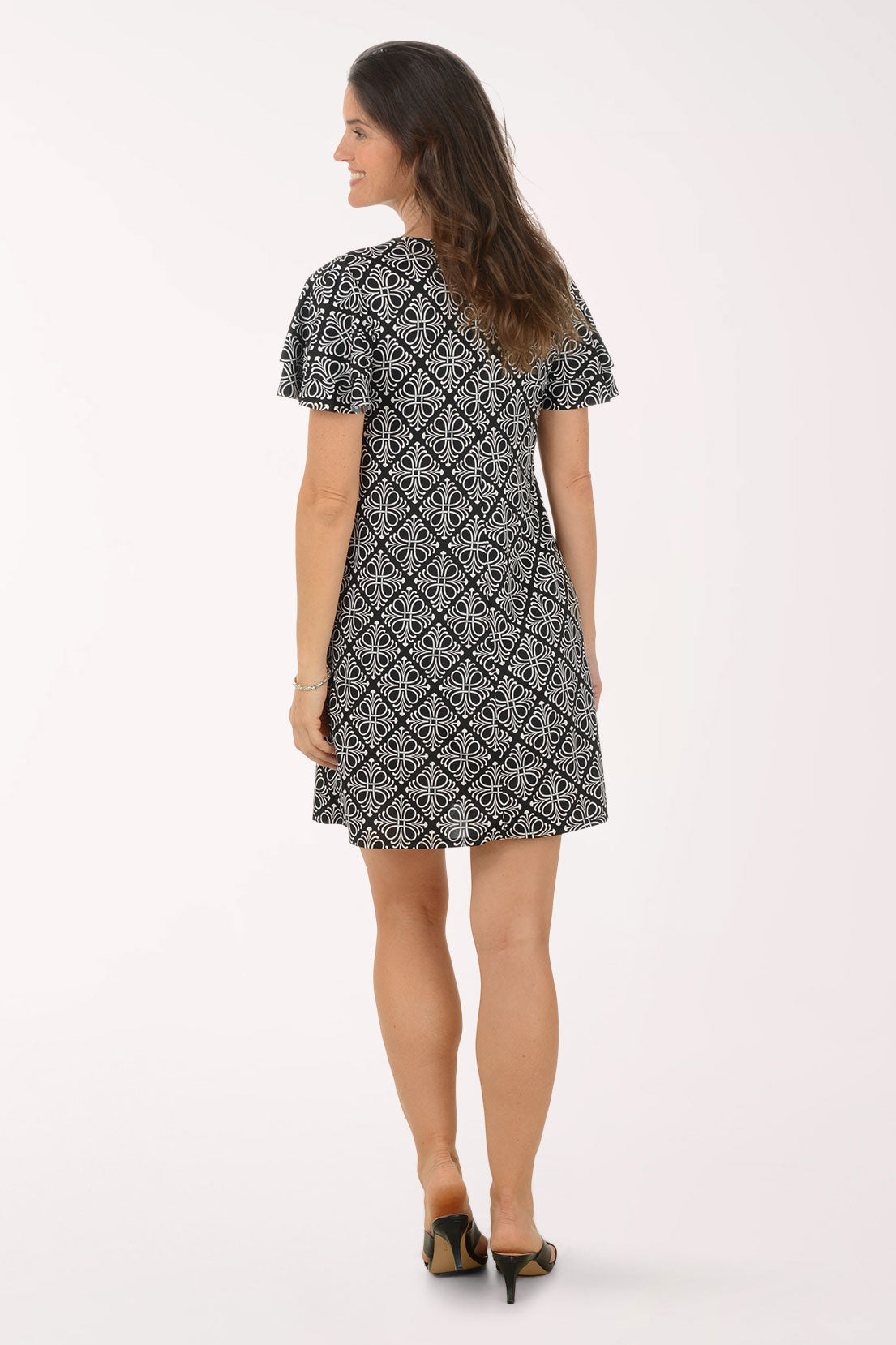 Woman wearing a black and white patterned dress on a white background