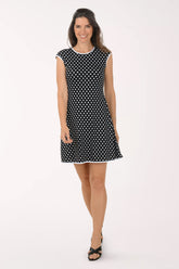 Woman wearing a black and white polka dot dress on a white background