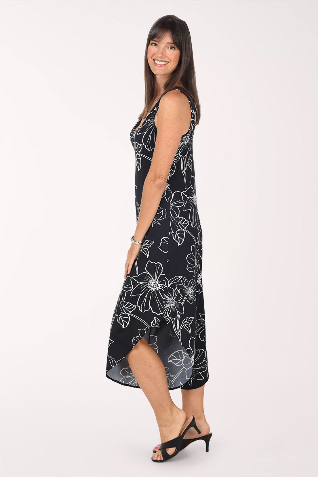 Side view of the Black Floral jumpsuit showing the relaxed fit through the body and the angled hem dipping lower at the back