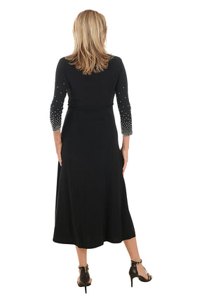 Woman wearing a black dress with embellished sleeves on a white background. Back shot.