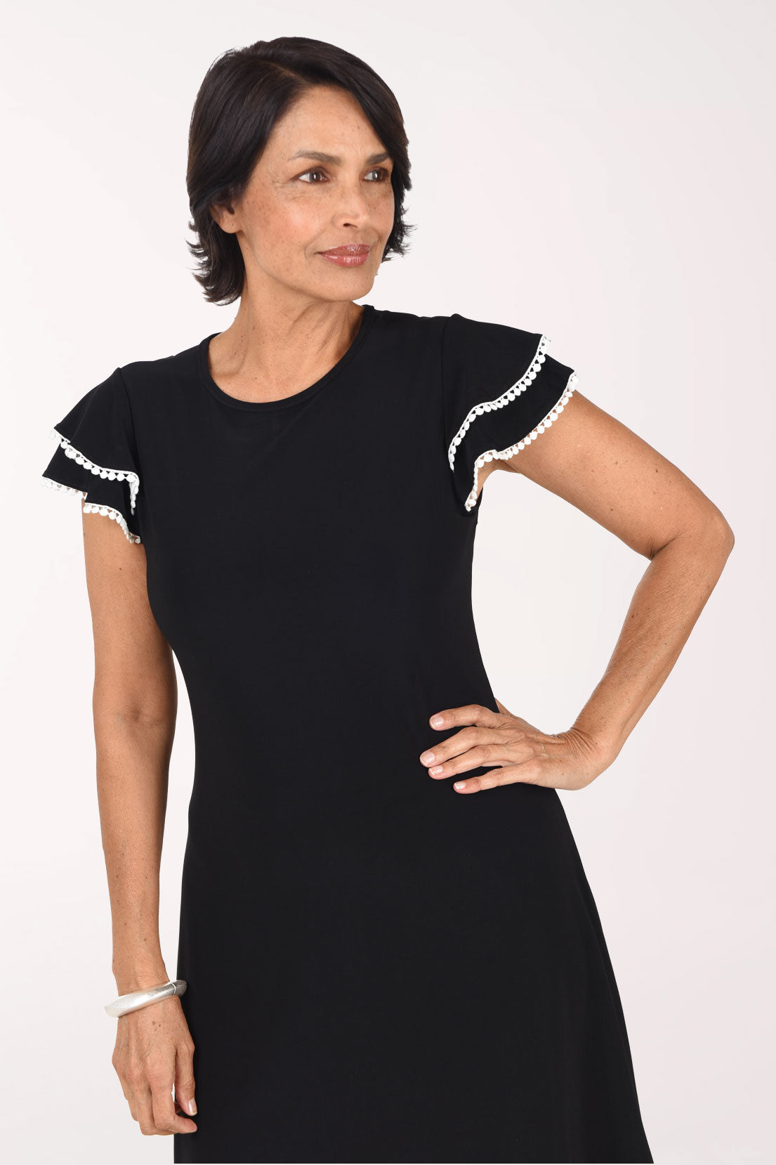 Close-up front view of the black Ric Rack Trim dress showing the scoop neckline, white-trimmed flutter sleeves and fitted bodice
