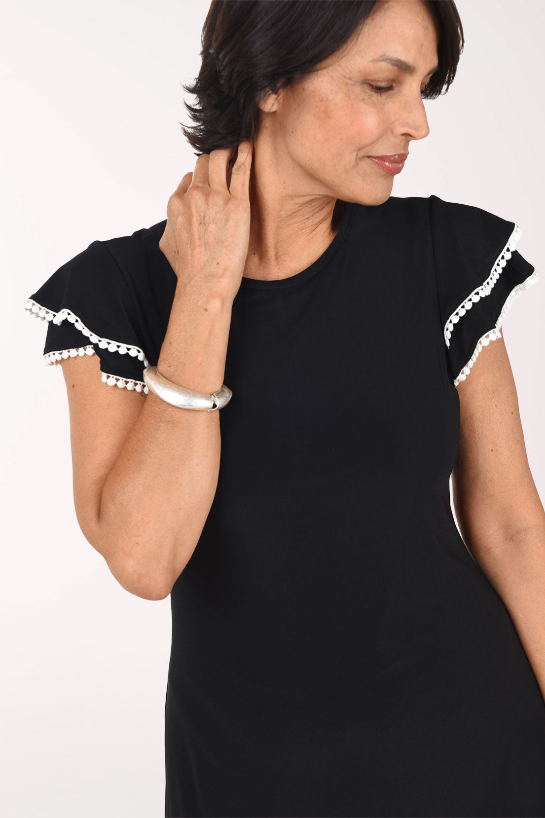 Close-up of the black Ric Rack Trim dress showing the two layers of flutter cap sleeve edged in wavy white rick rack trim