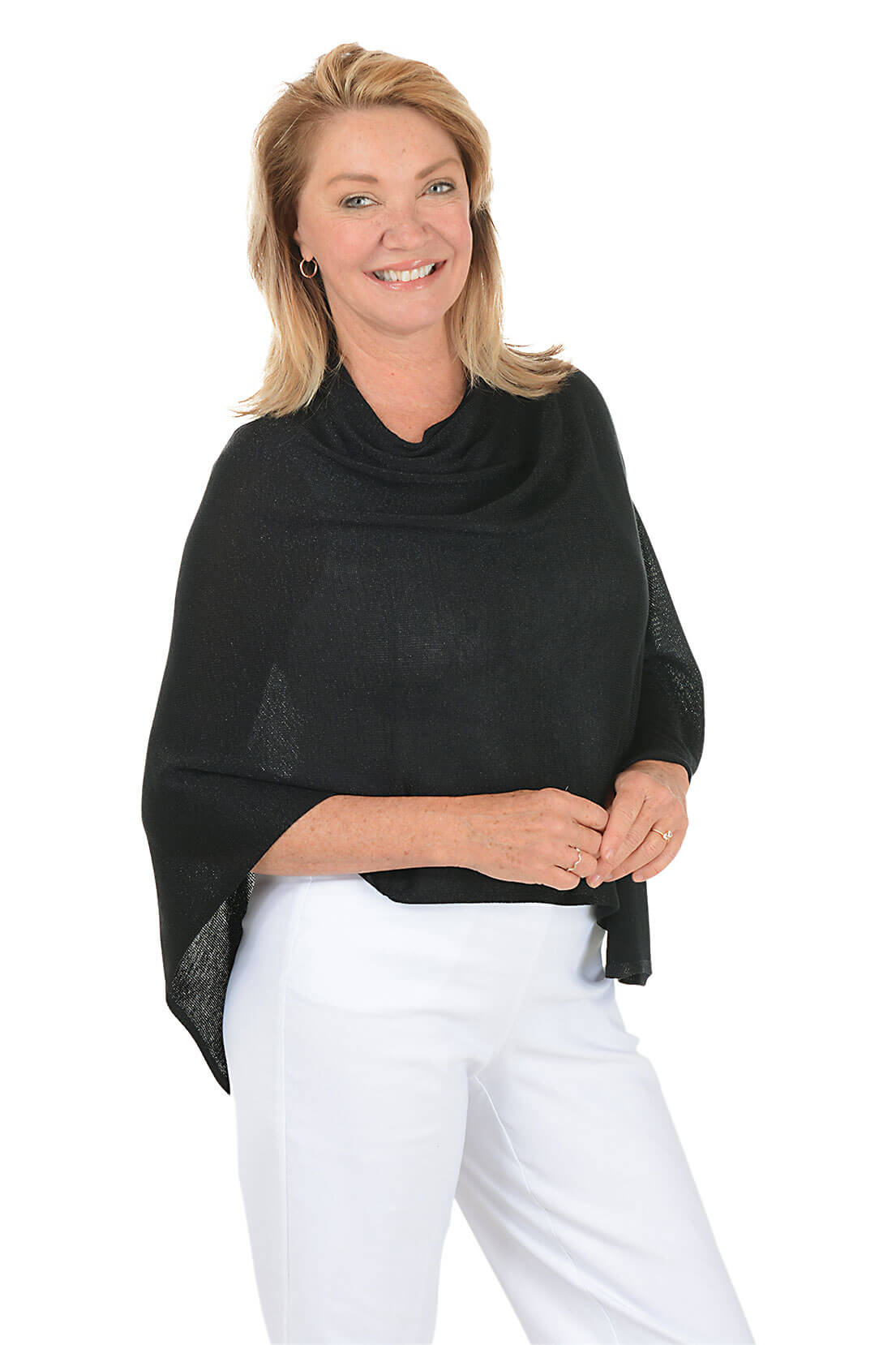 Woman wearing a metallic black poncho over a white outfit on a white background