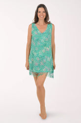 Woman wearing a teal floral dress with fringe on a white background