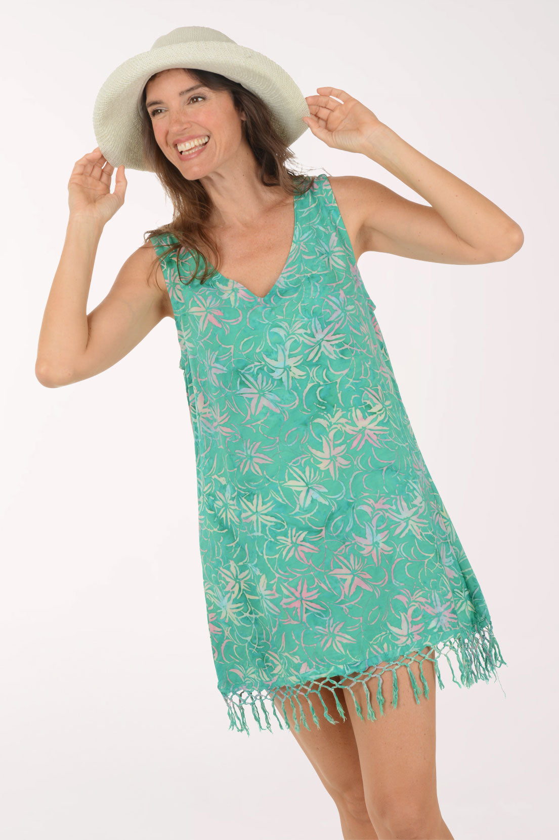Woman wearing a teal floral dress with fringe on a white background