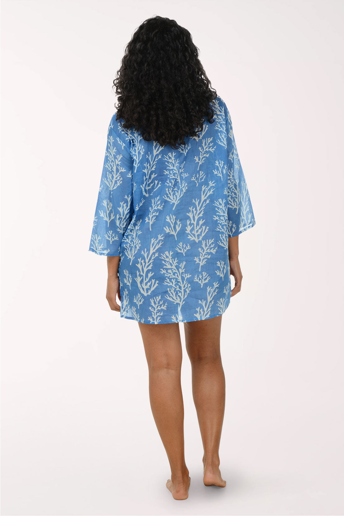 Woman wearing a blue floral dress on a white background