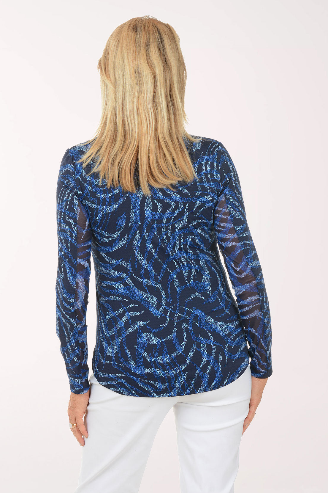 Woman wearing a blue patterned long-sleeve top on a white background