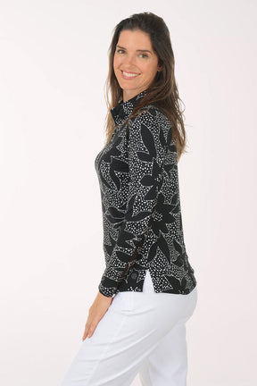 Woman wearing a black floral patterned shirt on a white background