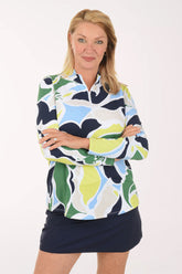 Woman wearing a colorful patterned top and navy skirt on a white background