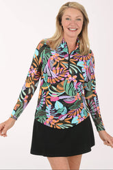 Woman wearing a colorful tropical print shirt and black skirt on a white background