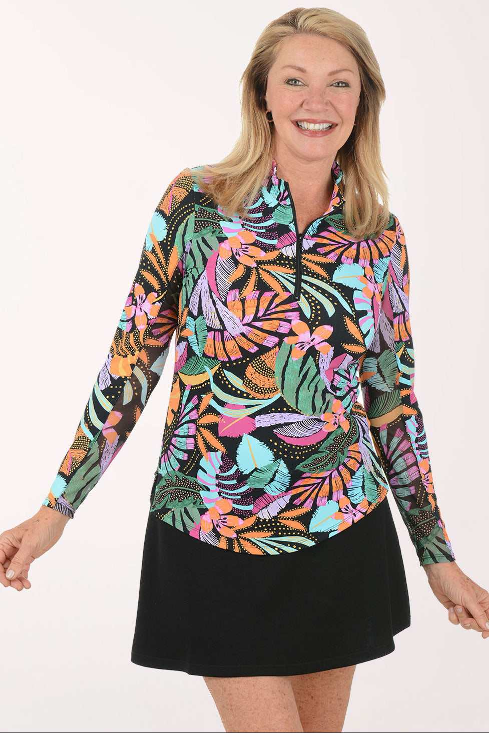 Woman wearing a colorful tropical print shirt and black skirt on a white background