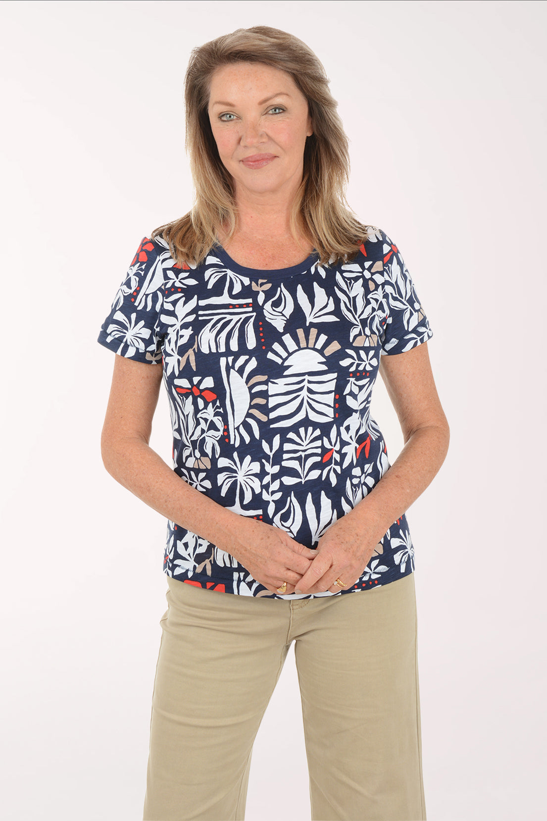Woman wearing a navy blue t-shirt with a colorful leaf pattern on a white background