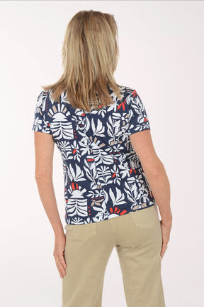 Woman wearing a navy blue t-shirt with a colorful leaf pattern on a white background