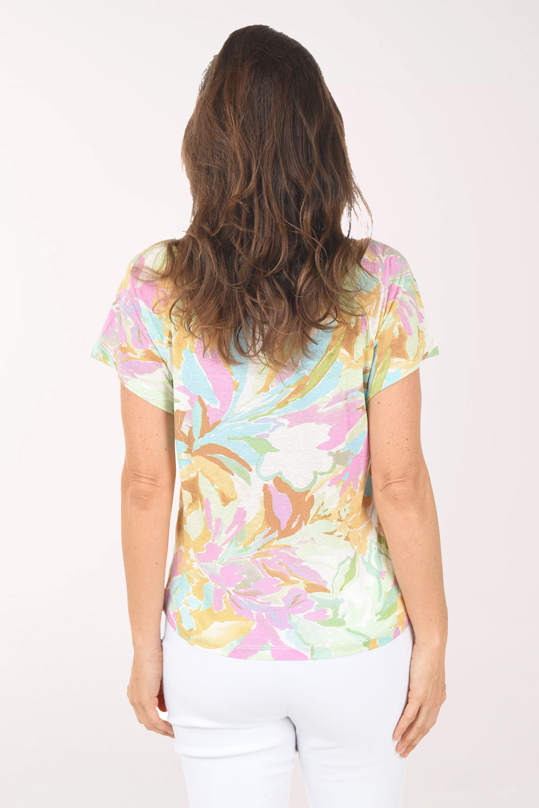 Woman wearing a colorful floral-patterned shirt on a white background