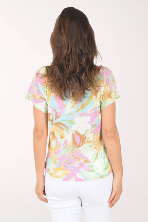 Woman wearing a colorful floral-patterned shirt on a white background