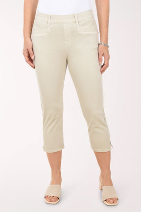 Person wearing beige capri pants on a white background