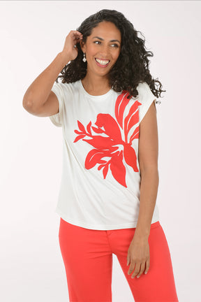 Woman wearing a white t-shirt with a red floral design and red pants on a white background