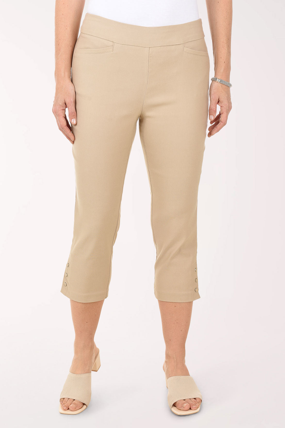 Beige capri pants worn by a person on a white background