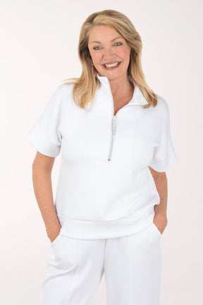 Woman wearing a white short sleeve top and skirt on a white background