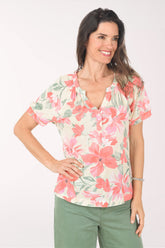 Woman wearing a floral blouse with pink and green colors on a white background