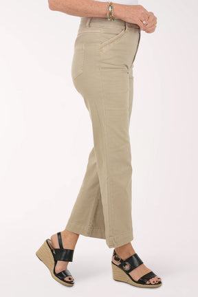 Person wearing beige wide-leg pants on a white background