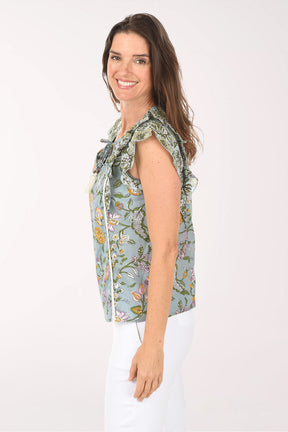 Woman wearing a floral sleeveless top with tassels on a white background