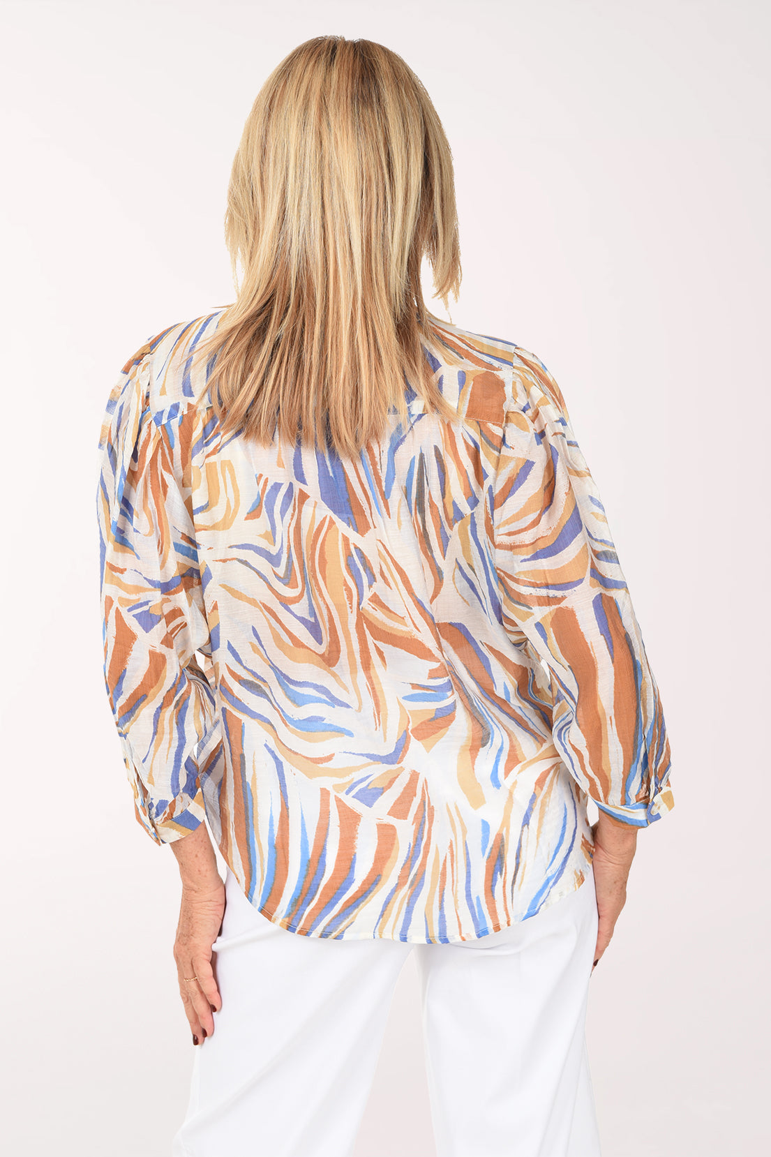 Woman wearing a patterned blouse with a white background