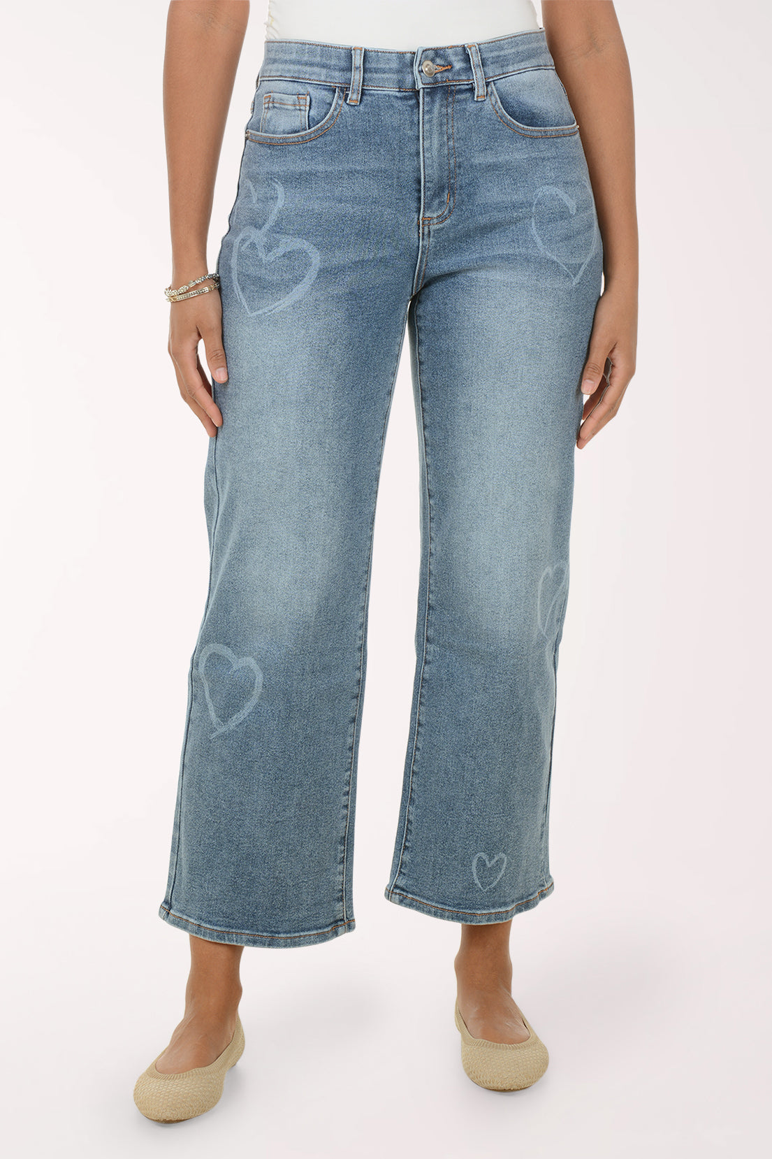 Woman wearing a white lace top and blue jeans on a white background